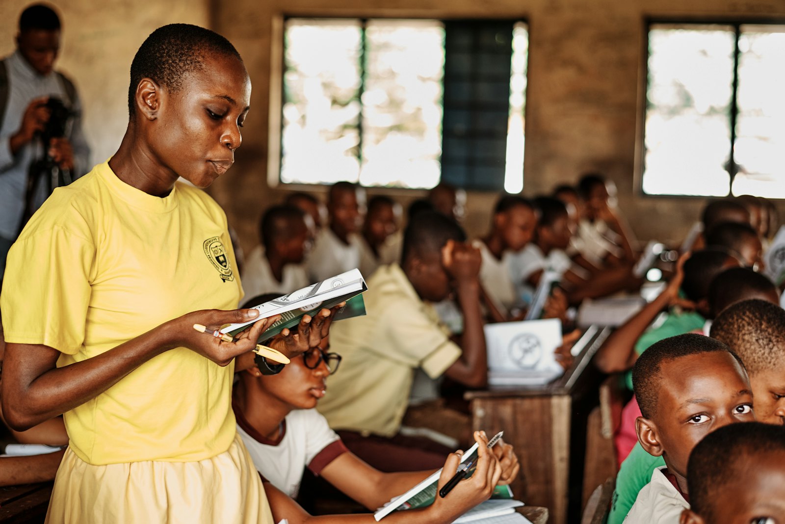 Students in yellow uniforms reading in a classroom