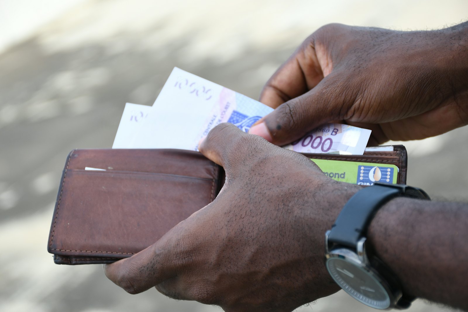 Hands counting banknotes from a leather wallet