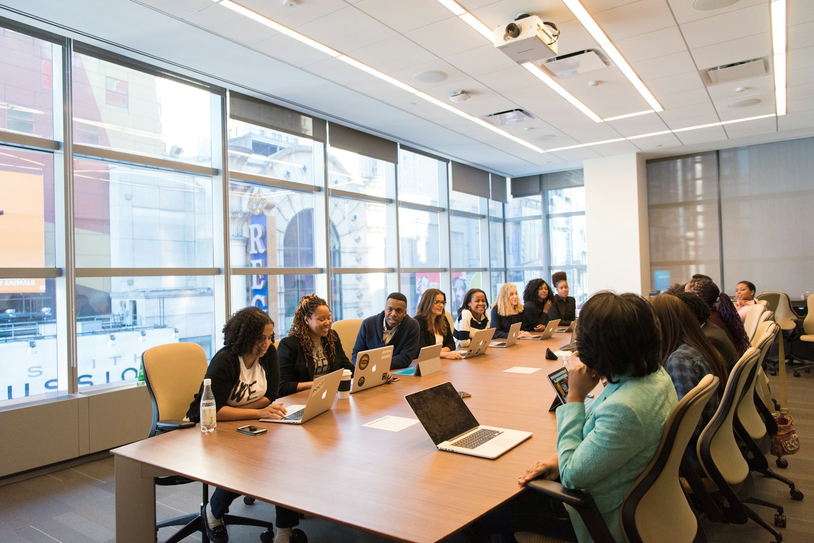 A team working on laptops around a boardroom table