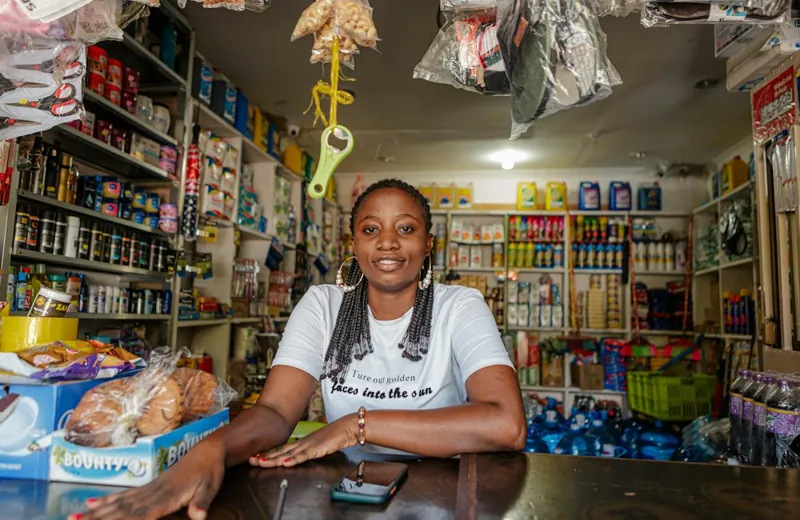 A shopkeeper smiling behind the counter of her shop
